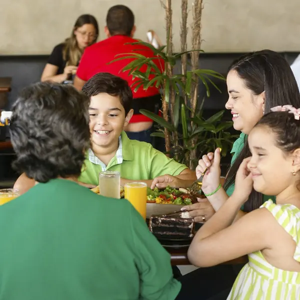Família reunida à mesa na Pães & Delícias