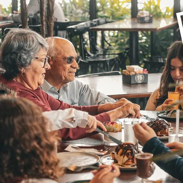 Casal de clientes à mesa no salão da Pães & Delícias